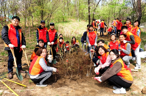 SK건설은 지난 13일 서울 성동구 서울숲에서 미세먼지 저감을 위한 나무심기 가족봉사 활동을 실시했다고 15일 밝혔다. SK건설 임직원 가족봉사단이 화단에 나무를 심고 기념촬영을 하고 있다.