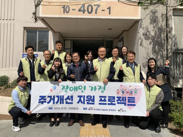 한국철도시설공단 충청본부 임직원이 밀알복지관 직원들과 함께 주거개선 지원 프로젝트를 위한 기념 사진을 찍고 있다