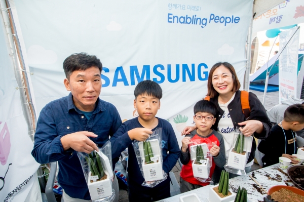 6일 부산에서 열린 '세상모든가족함께 바다 나들이' 행사에 참여한 시민들이 삼성전자 청소년자립지원 사업 소개 부스에서 화분만들기 체험을 즐기고 있다.