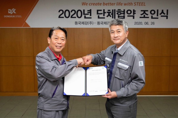 (오른쪽) 장세욱 동국제강 부회장과 박상규 노조위원장이 합의서를 들고 주먹 인사를 나누고 있다.
